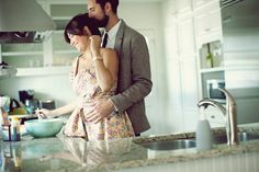 a man and woman are standing in the kitchen preparing food on the counter top, looking at each other