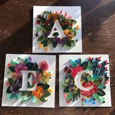 three cards with flowers on them and the letter d is made out of folded paper