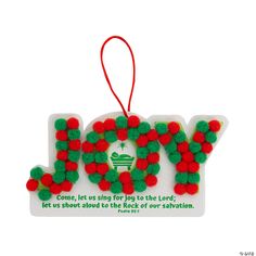 a christmas ornament with the word joy written in green and red pom - poms