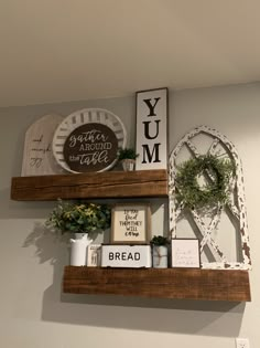 two wooden shelves with signs and other items on top of them, along with some wreaths