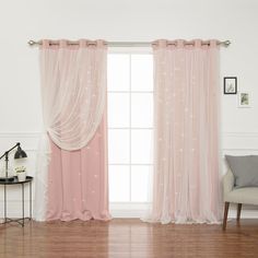 a living room with pink curtains and a chair