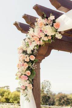 a wedding arch decorated with flowers and greenery