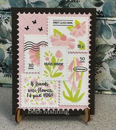 a stamp with flowers and butterflies on it is displayed in front of a floral wallpaper