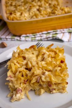 a white plate topped with macaroni and cheese next to a casserole dish