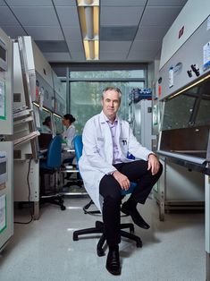 a man in a lab coat sitting on a chair