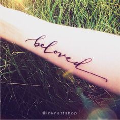 a person's arm with the word be loved written on it in cursive font