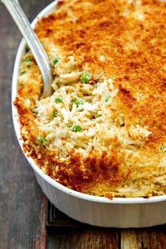 a casserole dish with broccoli and cheese in it on a wooden table