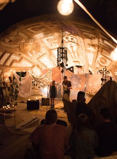 a group of people standing in front of a stage with lights and decorations on it