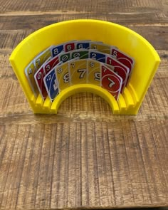 a yellow plastic game set sitting on top of a wooden table with numbers in it