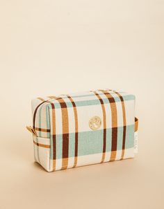 a brown and blue checkered toiletry bag on a beige background