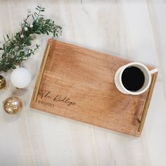 a wooden tray with a cup of coffee on it next to ornaments and greenery