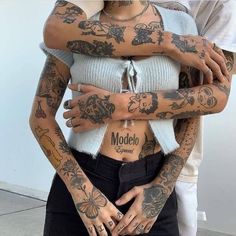 two people with tattoos hugging each other