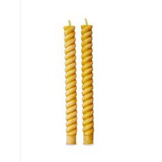 two yellow spiral candles sitting next to each other