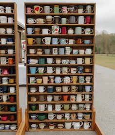 two wooden shelves filled with lots of coffee mugs