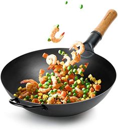 shrimp, peas and carrots being cooked in a wok on a white background