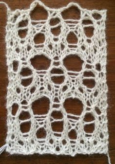 a close up of a white crochet on a wooden surface with yarn in the middle