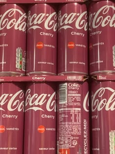 many cans of coca - cola are stacked on top of each other