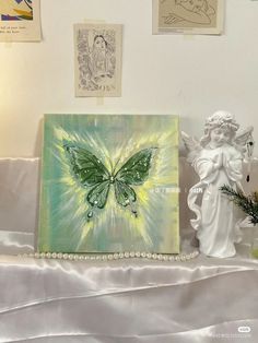 an angel statue sitting next to a painting