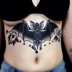 a woman with a bat tattoo on her stomach