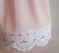 a pink nightgown with white lace trims and flowers on the bottom half