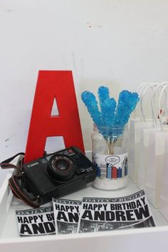 a white shelf topped with assorted items and a red letter sitting on top of it