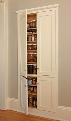 an open pantry cabinet in the corner of a room