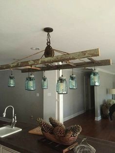 a kitchen island with mason jars hanging from it's ceiling and pine cones on the counter