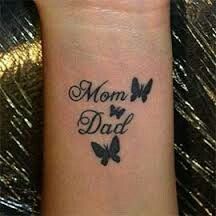 a woman's wrist with the words mom and two butterflies on her left arm