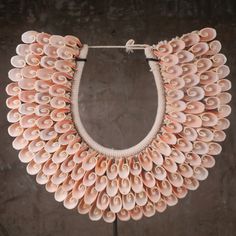 a necklace made out of seashells on a stand