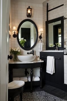 a bathroom with black and white tiles, a round mirror, two sinks and a toilet