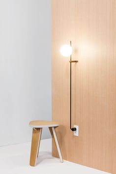 a wooden table sitting next to a wall with a light on it's side