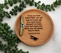 a wooden clock with a poem written on it and some green leaves around the clock