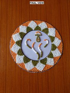 a small white and orange plate with an image of a chakra on it's side