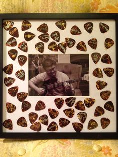 a guitar pick frame with an image of a man playing the guitar in his hand