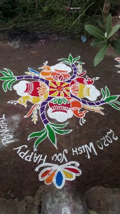 a colorful flower design on the ground with words written in white and red, green, yellow, blue, orange