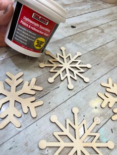 someone is making wooden snowflakes out of plywood and glue on the floor