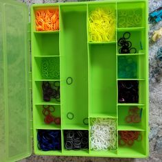 a green box filled with lots of different types of scissors and other crafting supplies