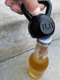 a person is holding a bottle with a weight on it