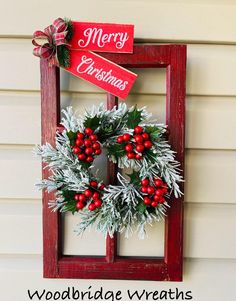 a christmas wreath hanging on the side of a house