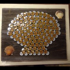 the bottle cap art is made to look like a fish with shells on it's back