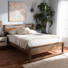 a bed sitting on top of a wooden floor next to a window