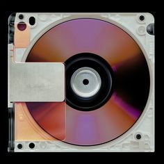 a close up view of a cd that is being held by a metal clipping