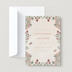 a wedding card with flowers and leaves on it, next to an envelope that has the word