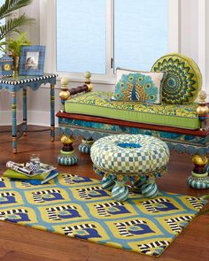 a living room filled with furniture next to a window covered in blue and green curtains