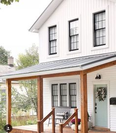 a white house with black windows and a porch