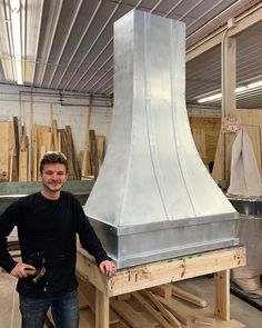 a man standing next to a large metal stove