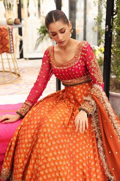 Orange Lehenga Skirt With Choli Pakistani Mehndi Wear is to Romanticize your style in this perfect attire. Pink choli is beautifully ornamented with kora, dabka, and zardozi embellishment all over. It is paired with strikingly elegant gradient tone chicken jamawar lehenga which is further enhanced with mukesh work and finished with embroidered lace all around. Lehenga Choli: This exquisitely beautiful choli comes in pink shades with sequence spray all over. To add a more festive vibe, you may pa Orange Lehenga Pakistani, Mehndi Lengha Pakistani, Bridal Mehndi Outfit Ideas, Dholki Outfit, Mehndi Outfit Ideas, Mehendi Dresses, Mehendi Dress, Pakistani Mehndi Dress, Mehndi Bride