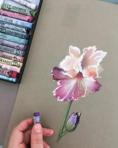 someone is drawing a flower with colored pencils