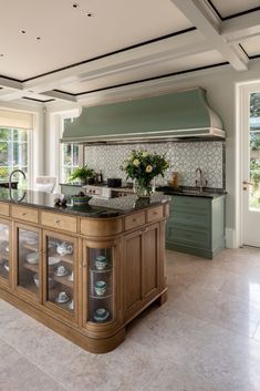 a large kitchen with an island in the middle and lots of cabinets on both sides