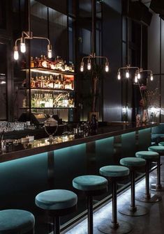 a dimly lit bar with stools and lights